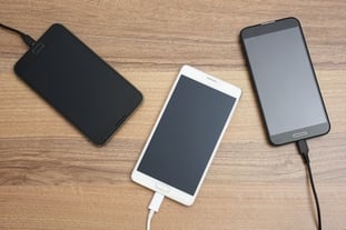 Mobile smart phones charging on wooden desk © Bacho Foto