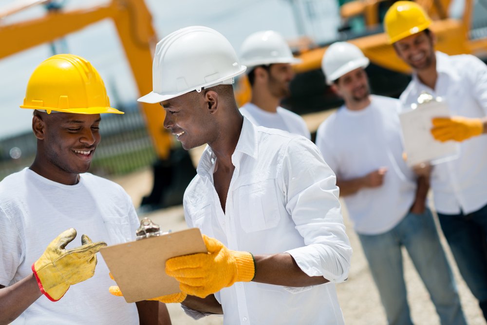 Happy architects working at a construction site outdoors