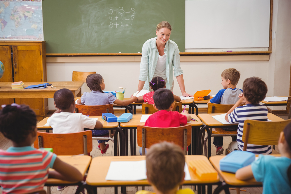 Teacher teaching to students in a classroom. 