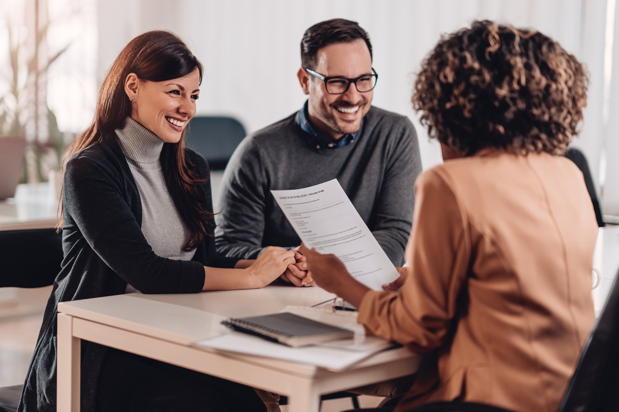 Couple consulting with female agent