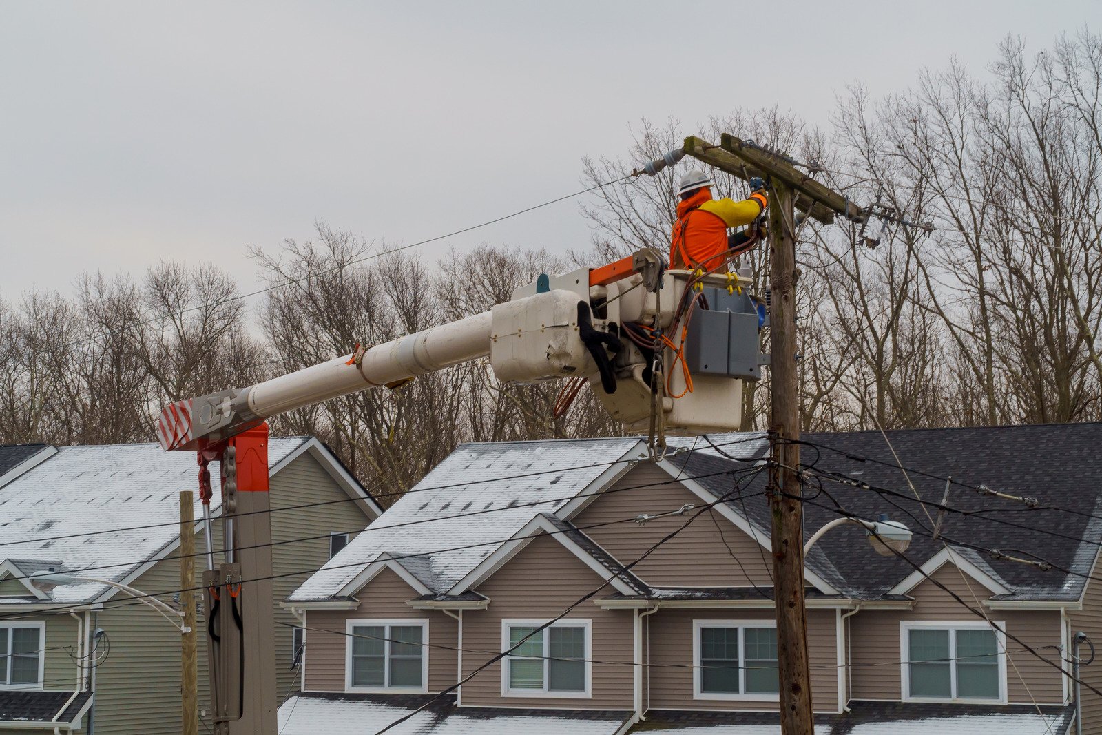 Utility worker repairing power lines in the winter